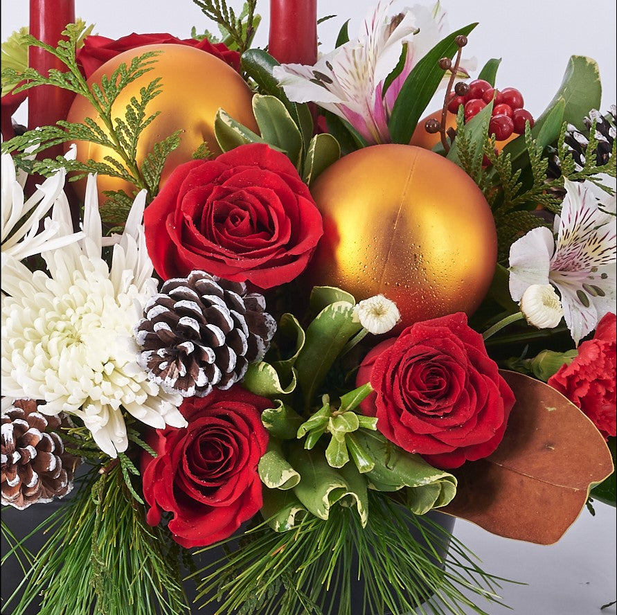 Candlelit Holiday Floral Arrangement, roses, spider chrysanthemums, carnations, chrysanthemums, pine cones, alstroemeria, and greenery in a metal tin container, Flower Gifts from Canada Blooms - Same Day Canada Delivery.