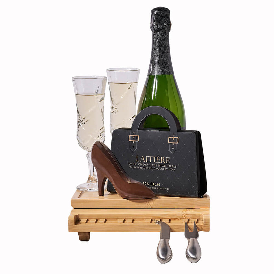 Champagne & Dark Chocolate Board, bottle of sparkling wine, two champagne flutes, a pair of dark chocolate high heels, and a grand piano serving board with tools inside, Champagne Gifts from Blooms Canada - Same Day Canada Delivery.