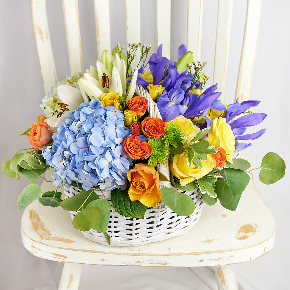 Irises In Paradise Mixed Arrangement, irises, roses, hydrangea, lilies, spray roses, daisies, and greens in a charming wicker basket, Flower Gifts from Canada Blooms - Canada Delivery