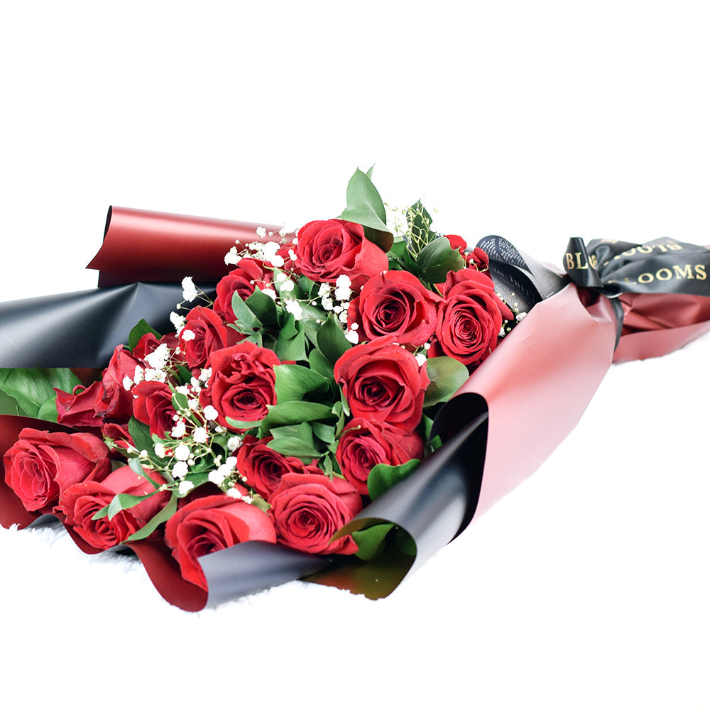 This bouquet includes a selection of deep red roses, baby’s breath, and ruscus gathered in floral wrap with designer ribbon. Blooms Canada Delivery